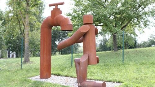 Skulptur Wasserhahn und Mensch